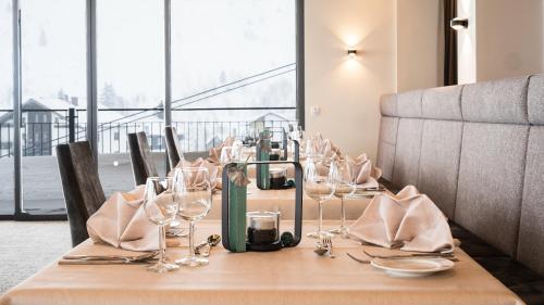 a table with wine glasses and napkins on it at Hotel Almhof in Galtür