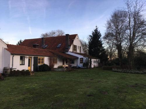 a white house with a grass yard in front of it at Hoeve de Knol in Holthees