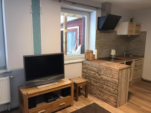 a living room with a television on a wooden stand at Ferienwohnung in Burg in Fehmarn