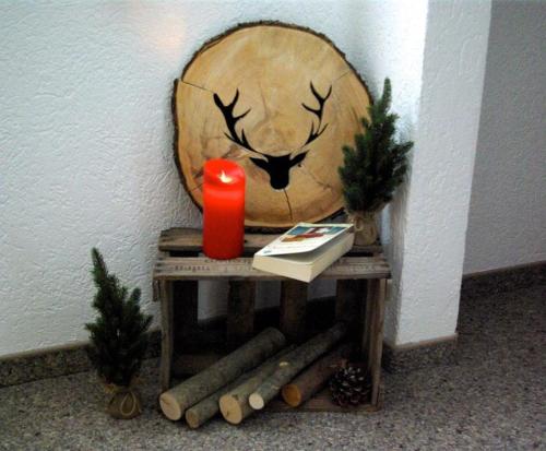 una mesa de madera con una vela y un tronco en Gästehaus Ulrich Neuner en Wallgau