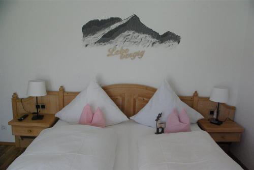 1 dormitorio con 1 cama con almohadas rosas en Gästehaus Ulrich Neuner en Wallgau