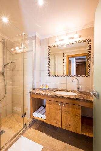 a bathroom with a sink and a shower at Hotel Almhof in Galtür