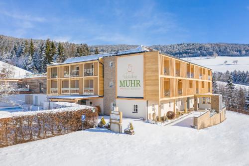 a large building with a sign on it in the snow at Hotel Muhr in Pöllauberg