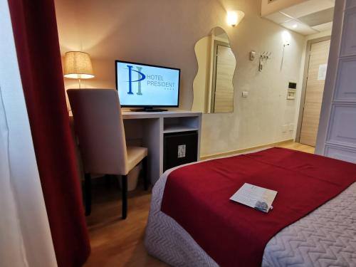 a room with a bed and a desk with a computer at Hotel President in Prato