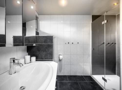 ein weißes Bad mit einem Waschbecken und einer Dusche in der Unterkunft Appartement Mountainview in Sankt Gallenkirch