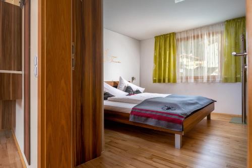 ein Schlafzimmer mit einem Bett und einem grünen Vorhang in der Unterkunft Appartement Mountainview in Sankt Gallenkirch
