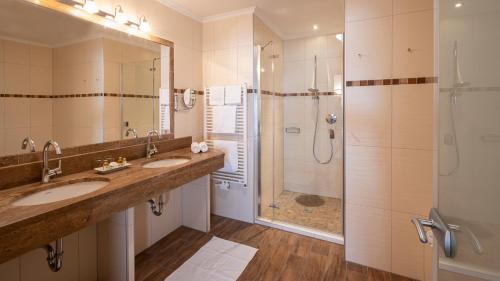 a bathroom with two sinks and a shower at Hotel Almhof in Galtür