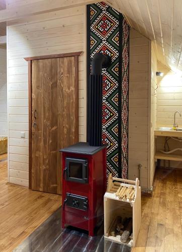 a room with a red stove and a door at Chalet PidStromom in Mykulychyn