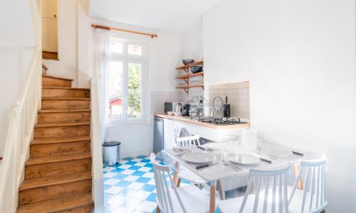 une cuisine avec une table et des chaises ainsi qu'un escalier dans l'établissement L'Escapade - Maison avec petit jardin - 4 pers, à Étretat