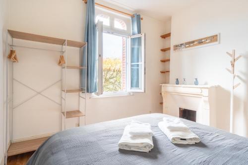 um quarto com uma cama com toalhas em L'Escapade - Maison avec petit jardin - 4 pers em Étretat