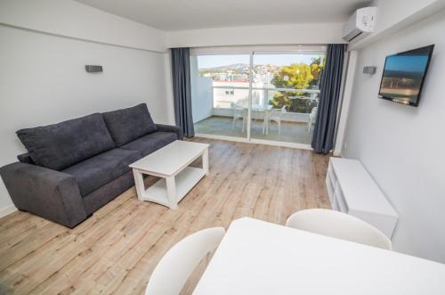 a living room with a couch and a table at Pierre&Vacances Mallorca Portofino in Santa Ponsa