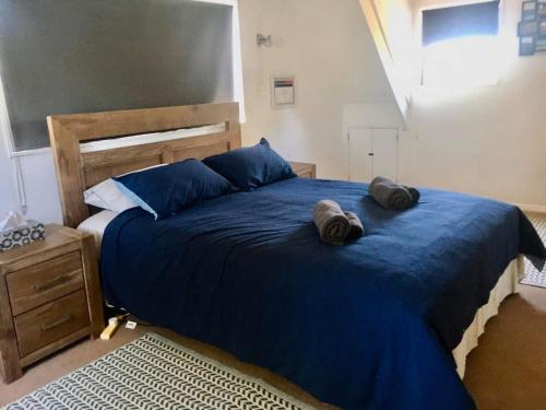 Un dormitorio con una cama azul con dos sombreros. en Hirangi cottage, en Turangi