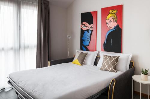 a bed in a room with paintings on the wall at Hotel Borgo Brianteo in Ponte San Pietro