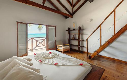 a bedroom with a bed with a view of the ocean at Clef des Iles in Beau Vallon