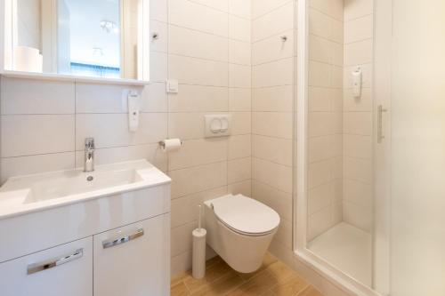 a bathroom with a toilet and a sink and a shower at Roomies Zagreb in Zagreb
