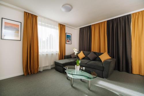 a living room with a couch and a glass table at Topáz Apartmanházak in Balatongyörök