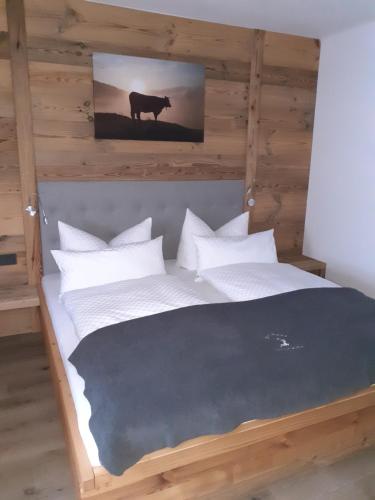 a bed with white pillows and a picture of a cow at Reithgut in Sankt Martin am Tennengebirge