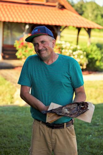 a man in a hat is holding a snake at Viesu nams RŪĶĪŠI in Rugāji