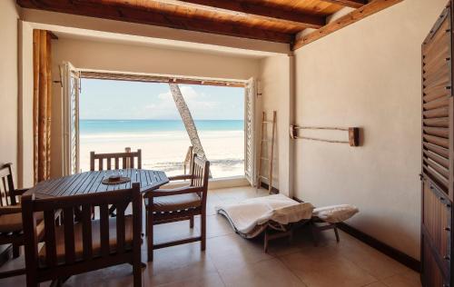 a dining room with a table and a view of the beach at Clef des Iles in Beau Vallon