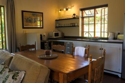 a kitchen with a wooden table and a dining room at Zebra Cottage and Lodge in Stellenbosch