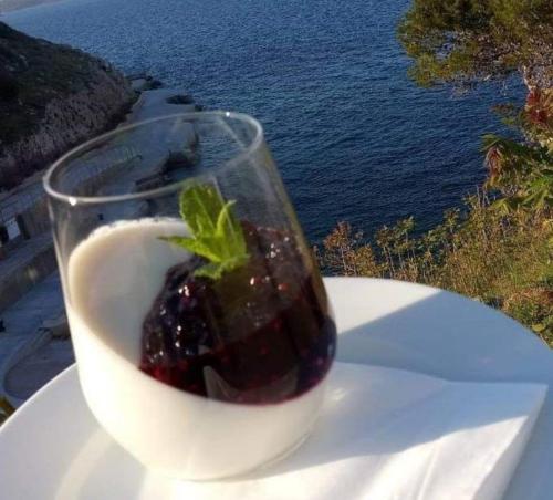 a drink in a glass on a table with a strawberry at Hotel Argentum in Vrbnik