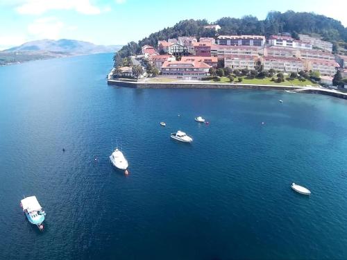 una vista aérea de los barcos en una gran masa de agua en Hotel Corcubión Playa de Quenxe en Corcubión