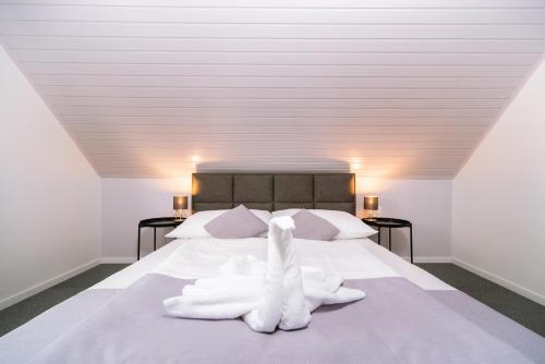 a bedroom with a bed with white towels on it at Topáz Apartmanházak in Balatongyörök