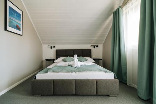 a bedroom with a bed in a attic at Topáz Apartmanházak in Balatongyörök
