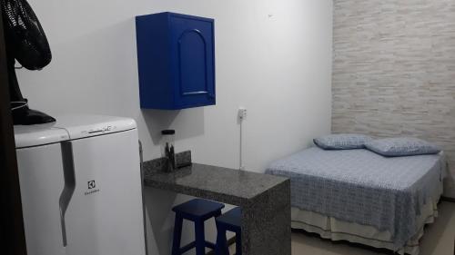 CLA - Quitinete Aotearoa في لاغونا: غرفة صغيرة بها سرير وخزانة زرقاء
