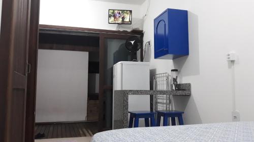CLA - Quitinete Aotearoa في لاغونا: غرفة نوم بها سرير واثنين من الكراسي الزرقاء