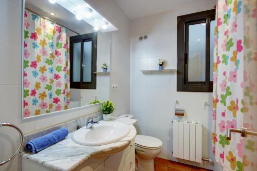 a bathroom with a sink and a toilet and a mirror at Migjorn 2 2 Roses - Immo Barneda in Roses