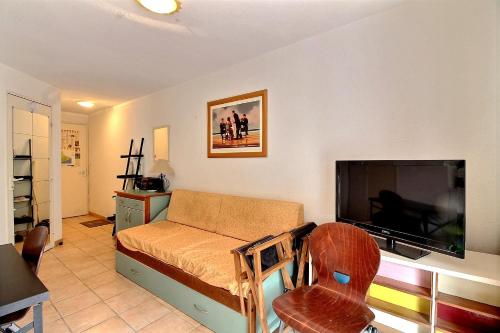 uma sala de estar com um sofá e uma televisão de ecrã plano em Appartement confortable dans une résidence à 50m de la plage em Valras-Plage
