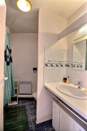 uma casa de banho branca com um lavatório e um WC em Appartement confortable dans une résidence à 50m de la plage em Valras-Plage
