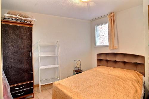 um quarto com uma cama e uma janela em Appartement confortable dans une résidence à 50m de la plage em Valras-Plage