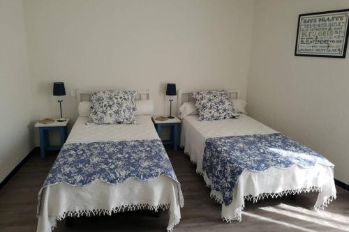 艾爾恩的住宿－Charmante maison de ville F3 avec garage et cour，配有两张蓝色和白色床单的床铺