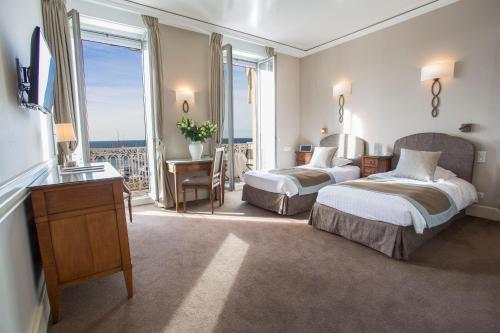 Habitación de hotel con 2 camas y balcón en Hotel Splendid en Cannes