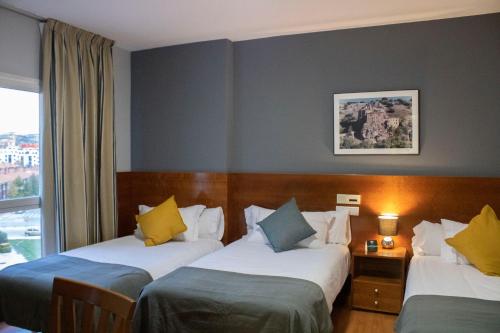 une chambre d'hôtel avec deux lits et une fenêtre dans l'établissement Hotel Alda Ciudad de Soria, à Soria