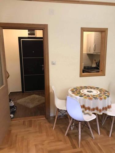 a dining room with a table and chairs and a mirror at GOski Apartman Brzeće Kopaonik in Brzeće