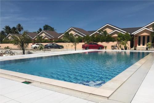 ein großes Schwimmbad vor einem Haus in der Unterkunft Nahdhoh Langkawi Resort in Pantai Cenang