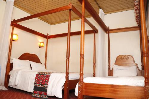 two four poster beds in a room at Park Place Hotel in Nairobi