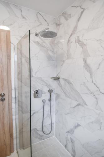 a bathroom with a shower with white marble at Hotel Palladium Sithonia in Kalamitsi