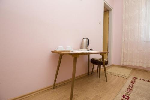 een houten tafel met een waterkoker in een kamer bij Rooms Anđela in Rab