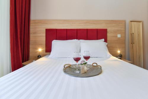 a bed with two glasses of wine on it at Hotel Palladium Sithonia in Kalamitsi