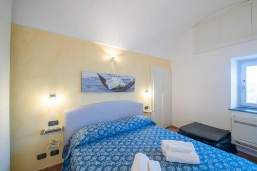 a bedroom with a bed with a blue comforter at Holiday House Nuvola in Amalfi Coast in Furore