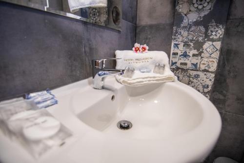 a bathroom sink with a towel on top of it at Hotel Palladium Sithonia in Kalamitsi