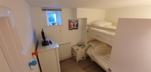 a small room with two bunk beds and a window at Offshore in Carbis Bay