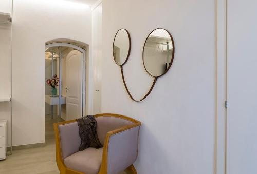 a room with a chair and two mirrors on a wall at Atem Villa Sicily, Spa and Pool in Modica