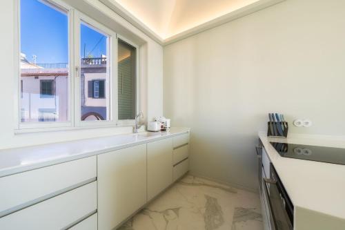 een keuken met witte kasten en een raam bij Barreirinha Front-Line Sea View II by HR Madeira in Funchal