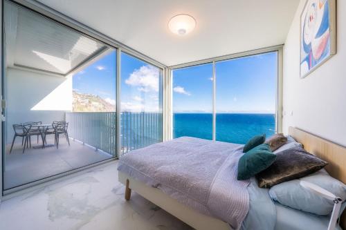 フンシャルにあるBarreirinha Front-Line Sea View II by HR Madeiraのベッドルーム1室(ベッド1台、大きなガラス窓付)