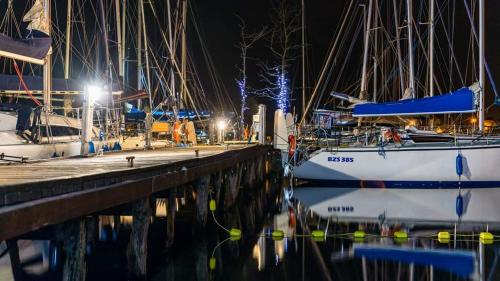 a group of boats docked at a dock at night at Przystań Tło dla Mew in Rydzewo